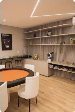 Mesa de jogos laranja com cadeiras brancas e estante decorada