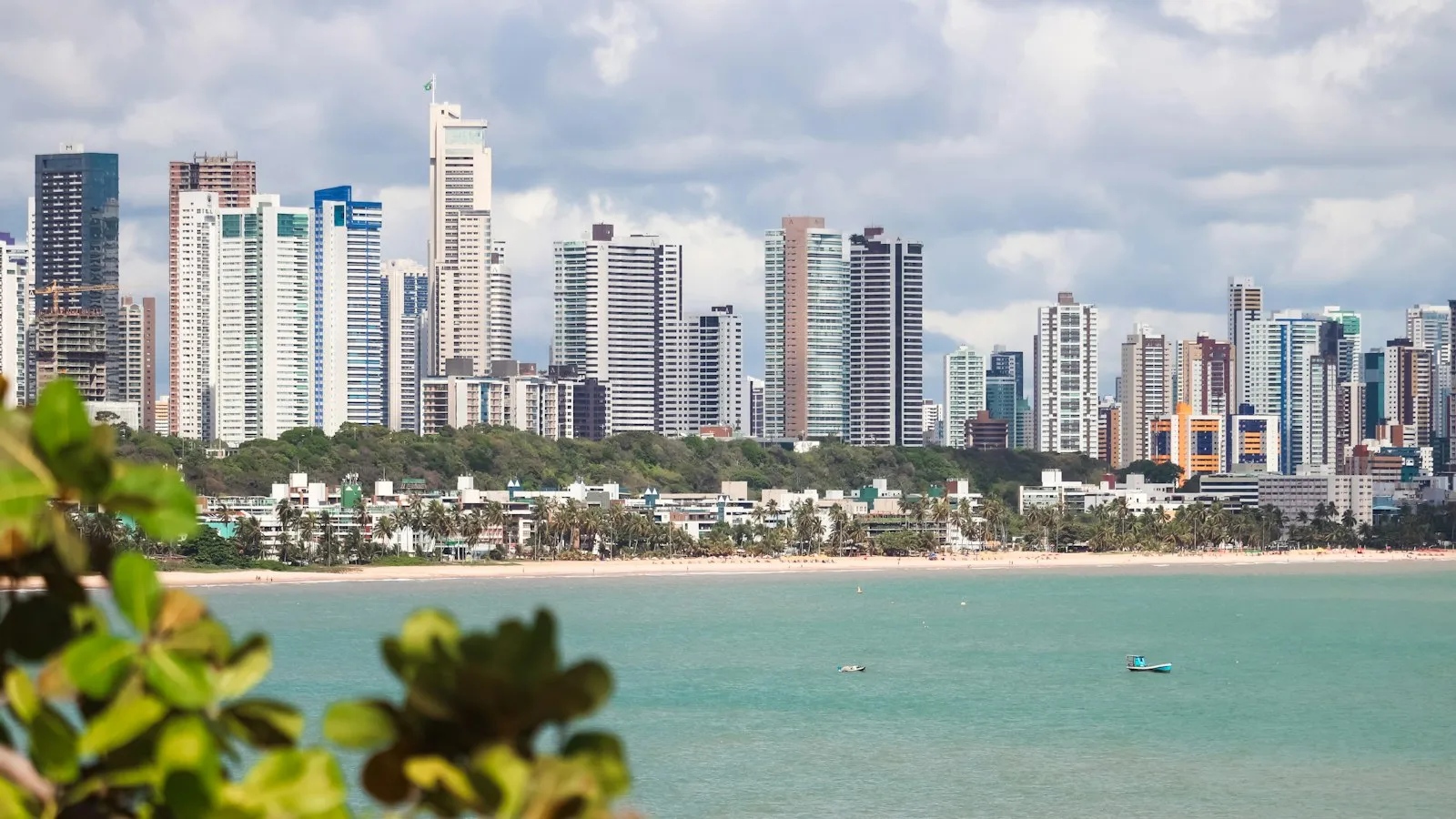 Prédios residenciais à beira-mar em João Pessoa vistos do outro lado da enseada