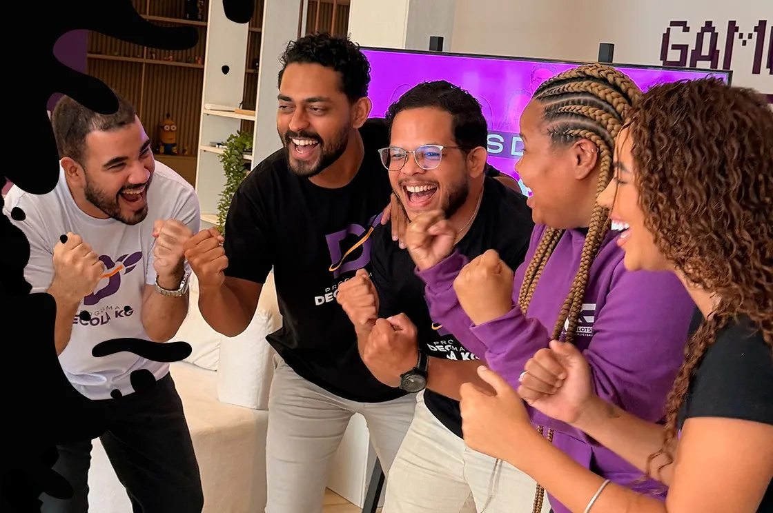 Equipe do Decola KG comemorando junta, com camisetas do programa, em um escritório